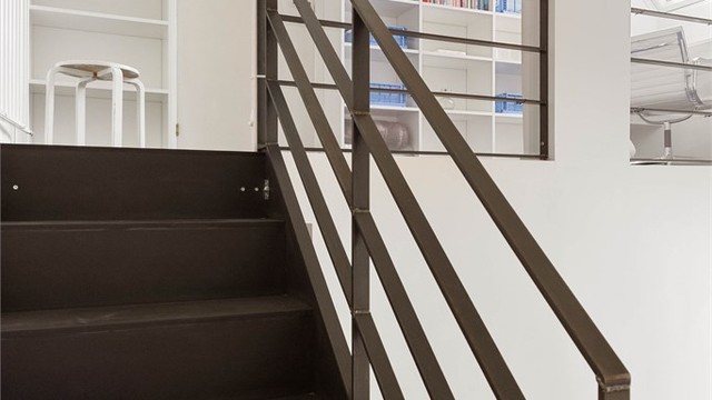 Der trappen ender, åpner mesaninen seg med plassbygde bokhyller som en naturlig fortsettelse av rommet.