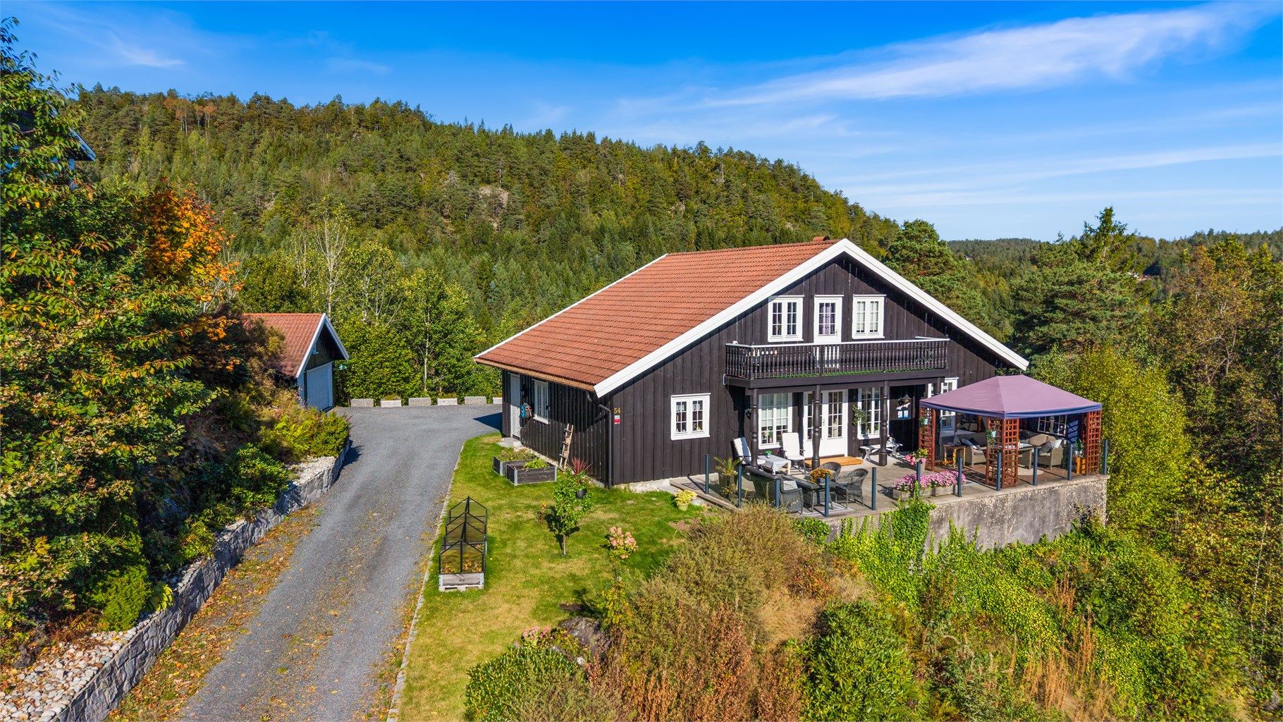 Eiendommen er omkranset av skog og frodig natur i et veletablert boligområde.