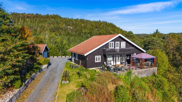 Eiendommen er omkranset av skog og frodig natur i et veletablert boligområde.