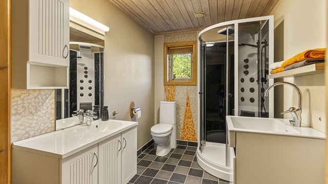 Badet i første etasje har flislagt gulv med varme, vegghengt servantskap og opplegg for vaskemaskin.