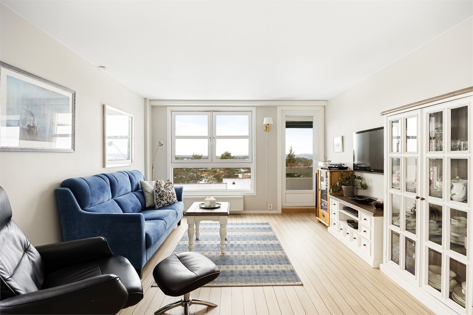 Stuen fremstår moderne med lyse overflater og gjennomgående gulv.