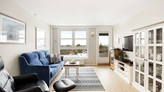 Stuen fremstår moderne med lyse overflater og gjennomgående gulv.