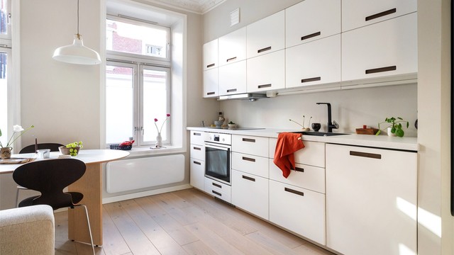 Kjøkkeninnredningen har glatte fronter og integrerte hvitevarer som induksjonstopp, stekeovn og oppvaskmaskin.