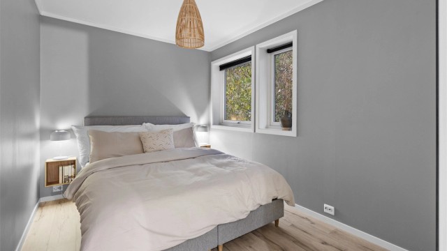 Hovedsoverom med en-stavs laminat på gulv og god plass til dobbeltseng.