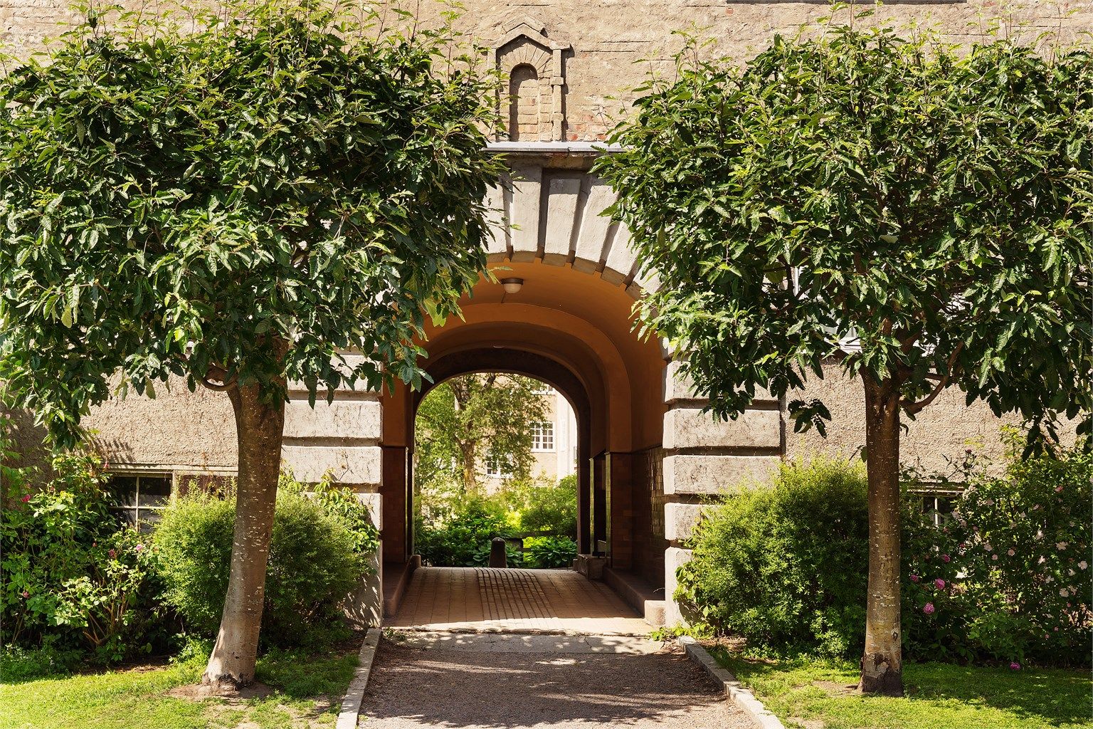 Idyllisk entré via portrommet og bakgård.