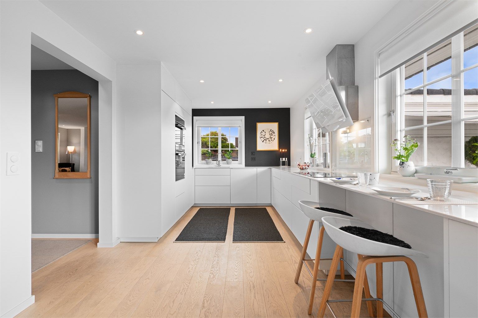 Moderne kjøkken fra KVIK med glatte, hvite fronter og benkeplate i Corian