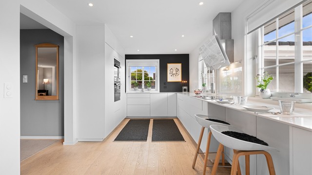 Moderne kjøkken fra KVIK med glatte, hvite fronter og benkeplate i Corian