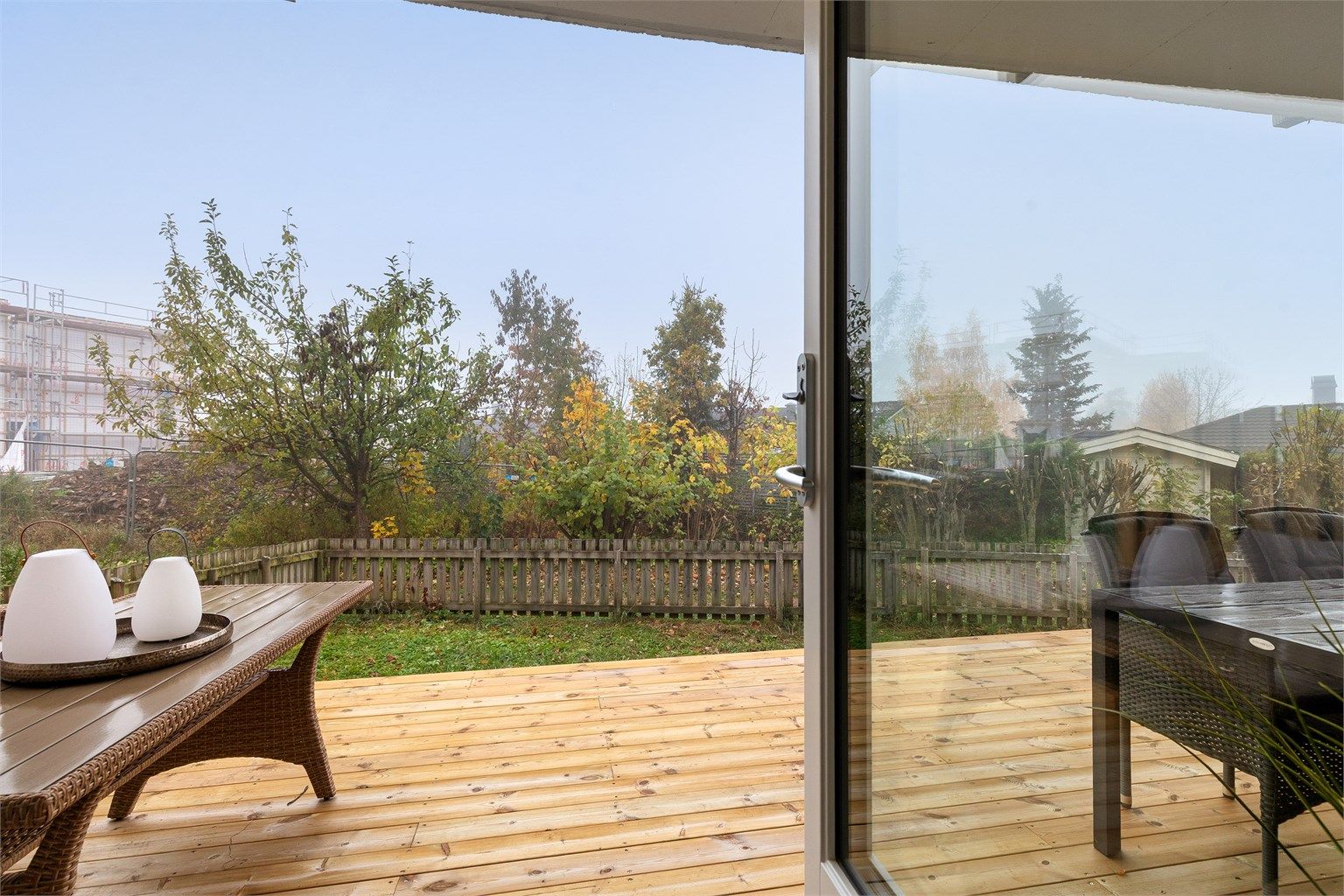 Fra stuen åpner terrassedøren direkte ut mot treterrassen og hagen.