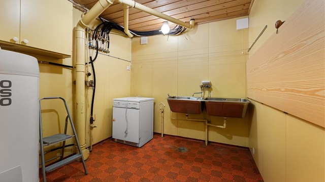 Praktisk vaskerom med utslagsvask, opplegg for vaskemaskin og plassering av varmtvannsbereder.