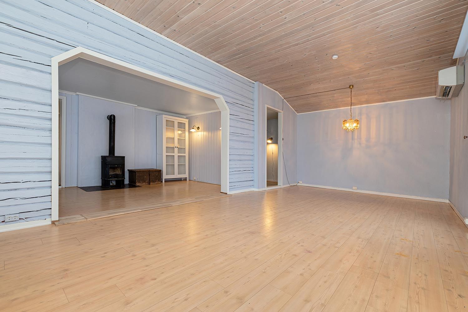 Lys stue av god størrelse med plass til flere sittegrupper.