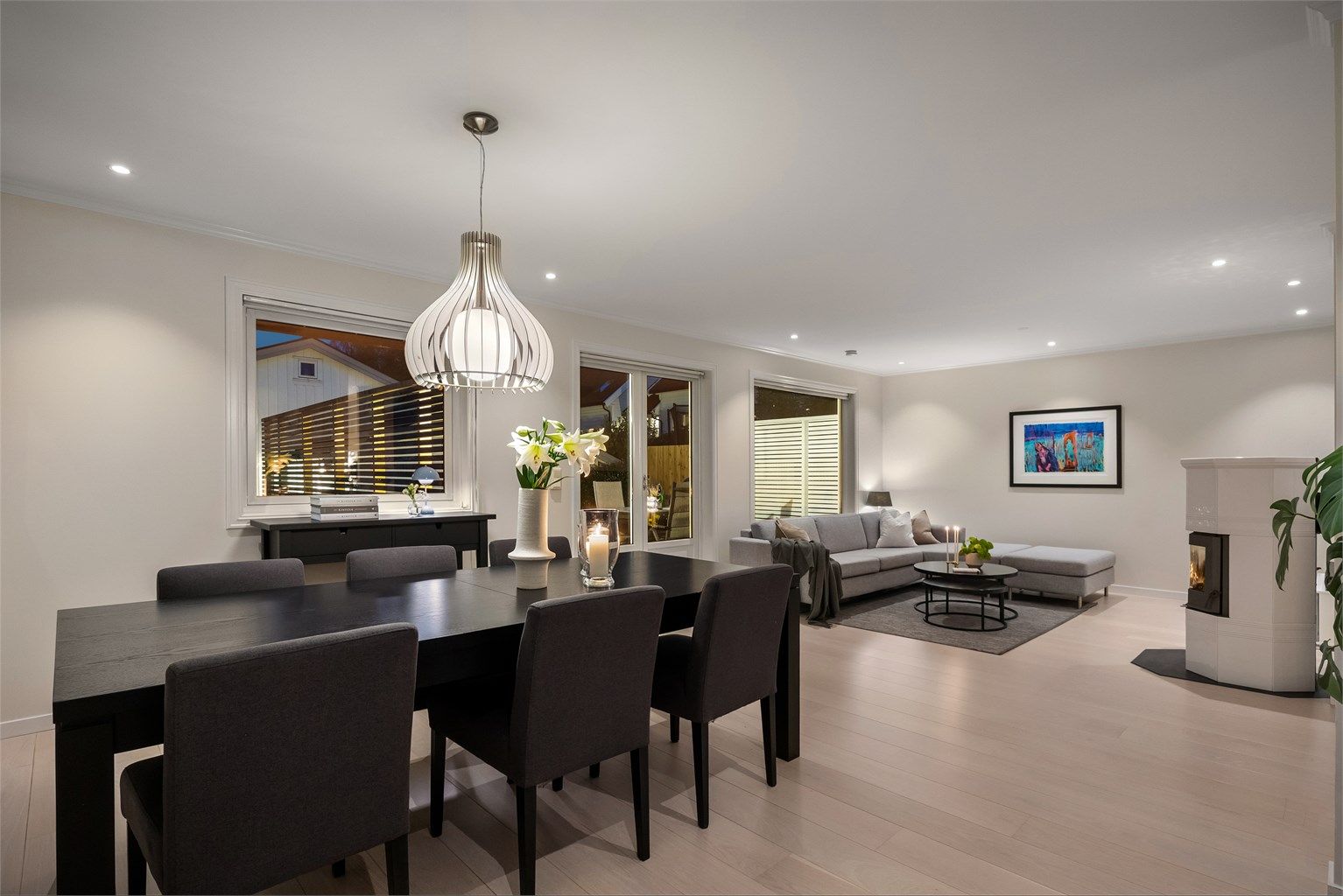 Lys og romslig kombinert stue og spisestue med 1-stavs parkett, peisovn og utgang til stor sydvendt terrasse på 35 kvm