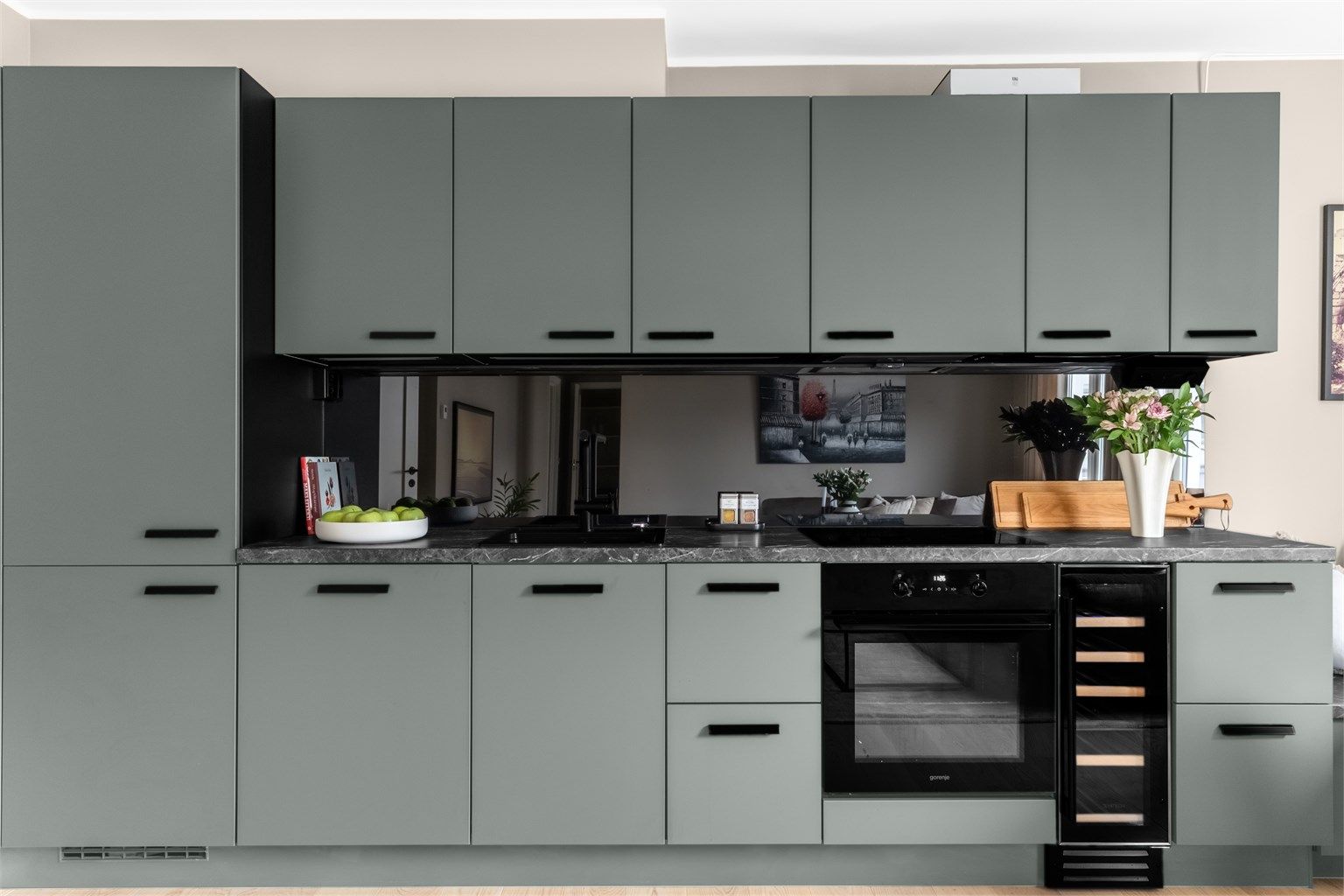 Kjøkkenet består av integrerte hvitevarer bestående av ovn, induksjonstopp, kjøl/frys, vinskap og oppvaskmaskin