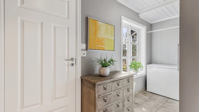 Vaskerom fra byggeår. Flislagt gulv med gulvvarme. Vegghengt innredning med nedsenket utslagsvask med armatur. Mekanisk avtrekk med ventil i vegg. Opplegg for vaskemaskin.