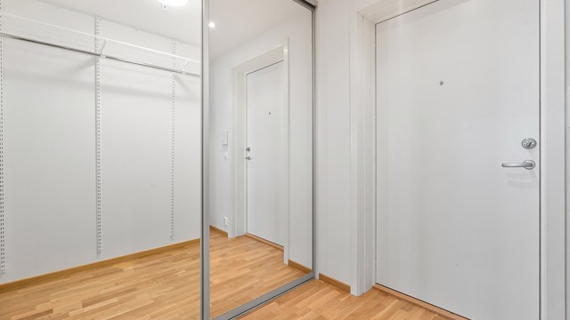 En stor skyvedørsgarderobe med speilfronter gir rikelig med oppbevaringsplass for yttertøy og sko.
