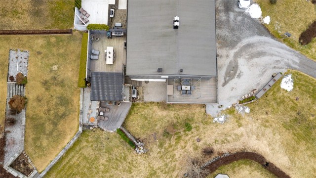 Tomten er opparbeidet med gruslagt gårdsplass, plenarealer og beplantning