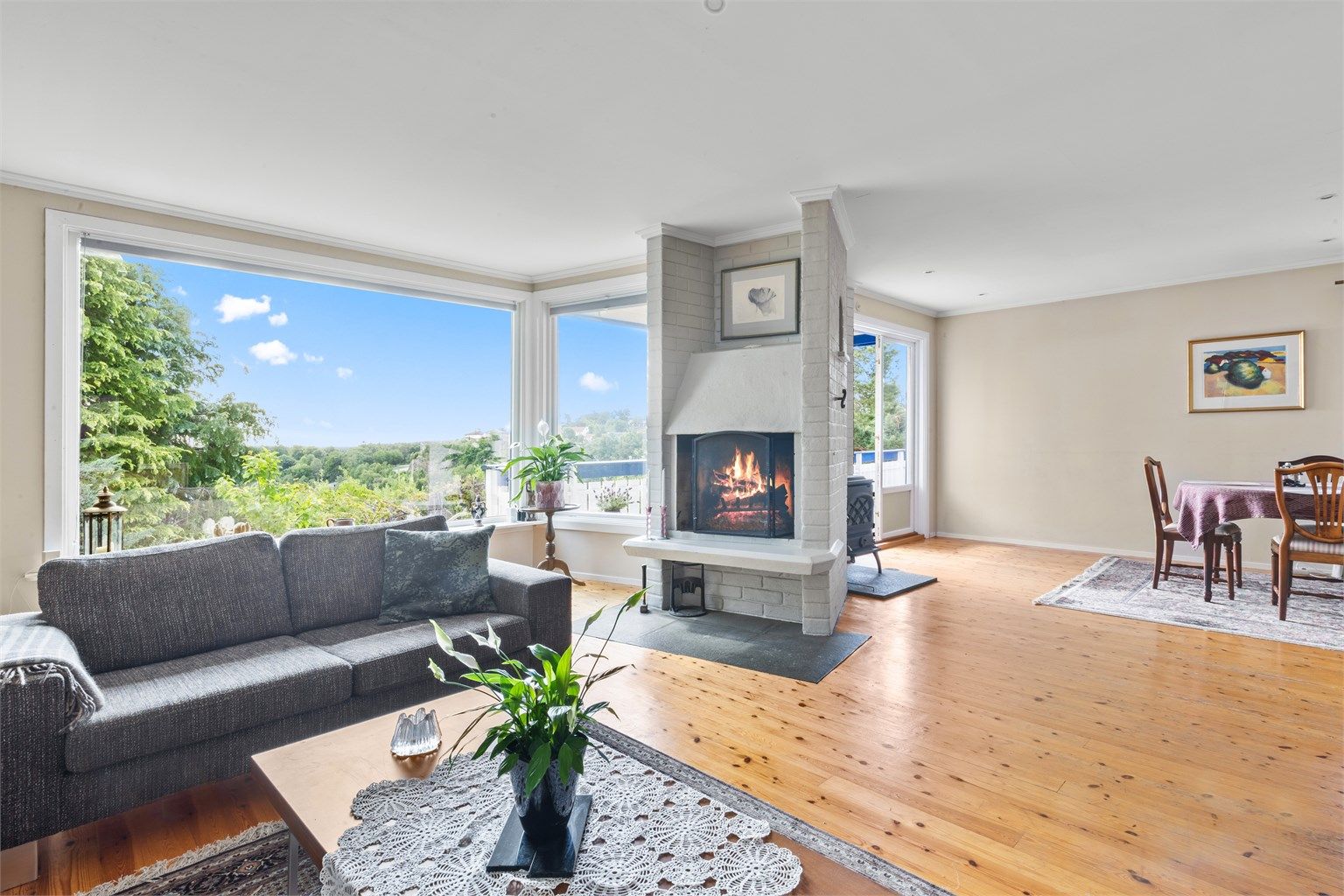 Romslig og åpen stue med god romfølelse, store vindusflater og åpen peis i tillegg til vedovn. 