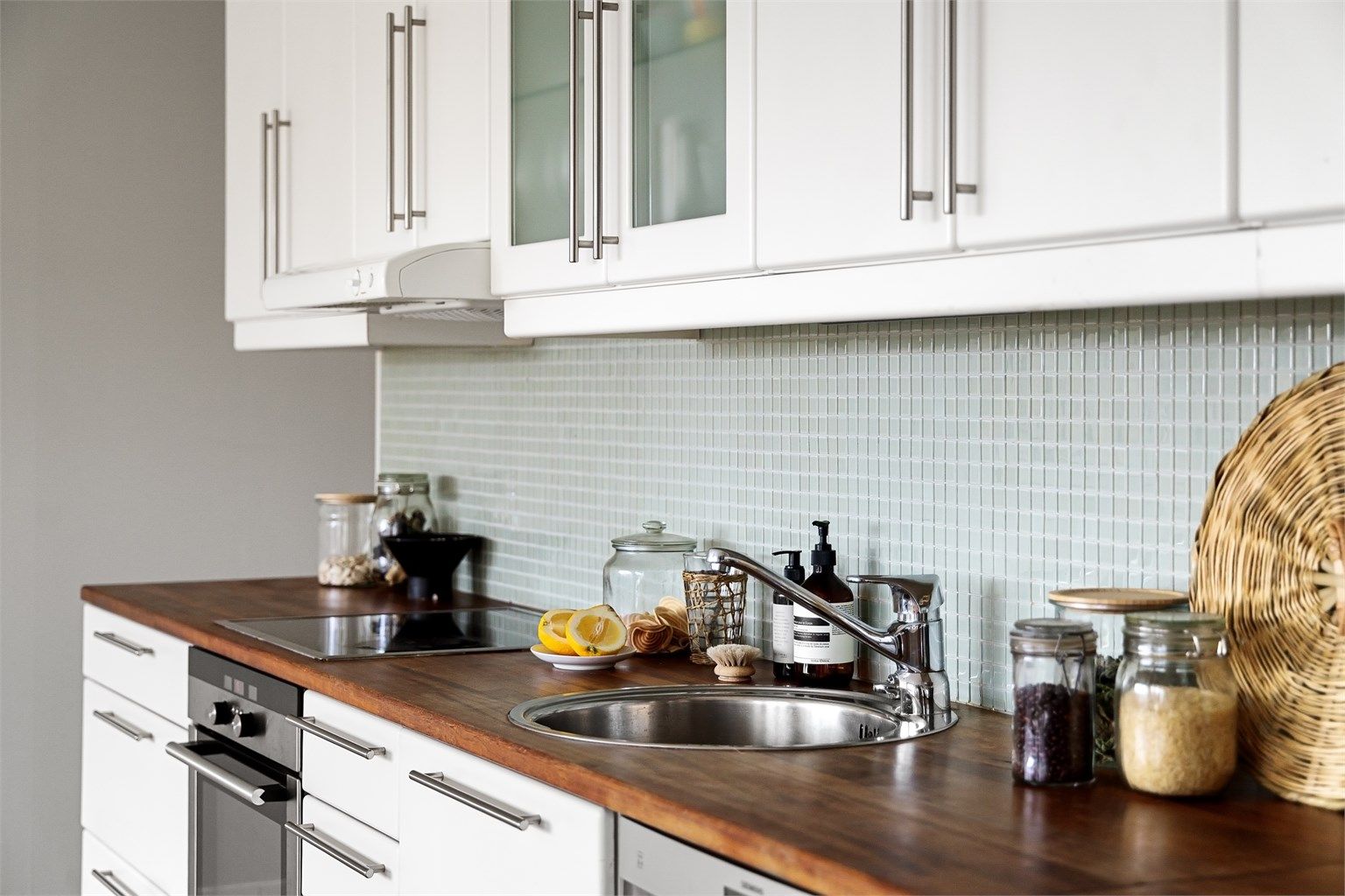 Mosaikkfliser, belysning og stikkontakter mellom benk og overskap