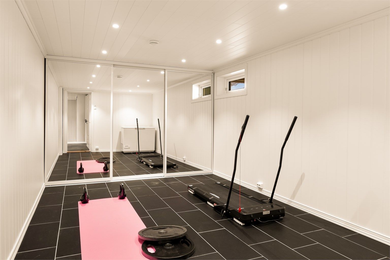 Treningsrom med skyvedørsgarederobe i underetasjen.