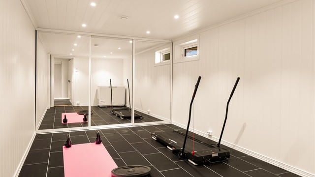 Treningsrom med skyvedørsgarederobe i underetasjen.