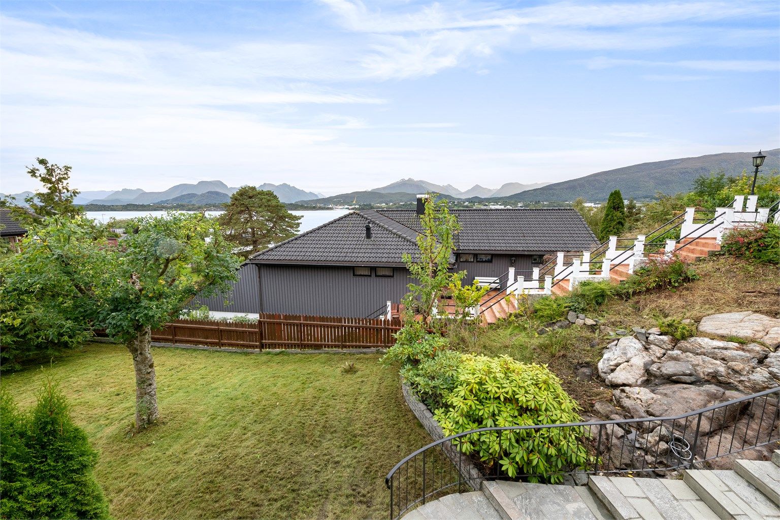 Utsikt mot fjorden og fjellene fra eiendommens uteområder.