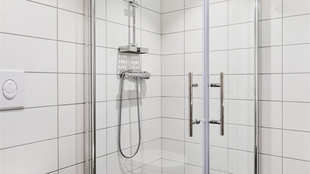 Praktisk dusjhjørne med innfellbare glassdører og hånddusj. Badet har mekanisk avtrekk.