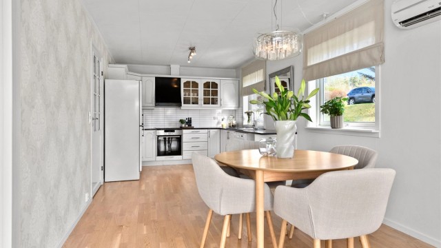 Kjøkkenet har en praktisk spiseplass og åpen forbindelse til stuen