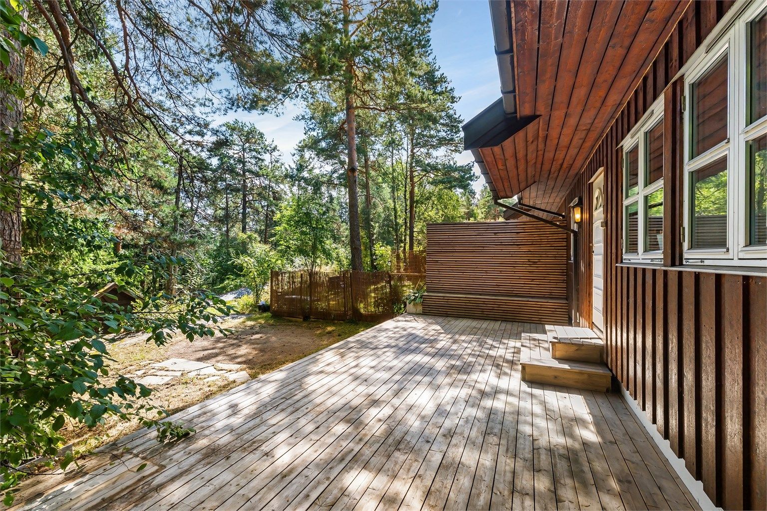 Østvendt terrasse ved kjøkkenet, fint plassert mot grønne og skjermede omgivelser (fremgår ikke av godkjente byggetegninger).