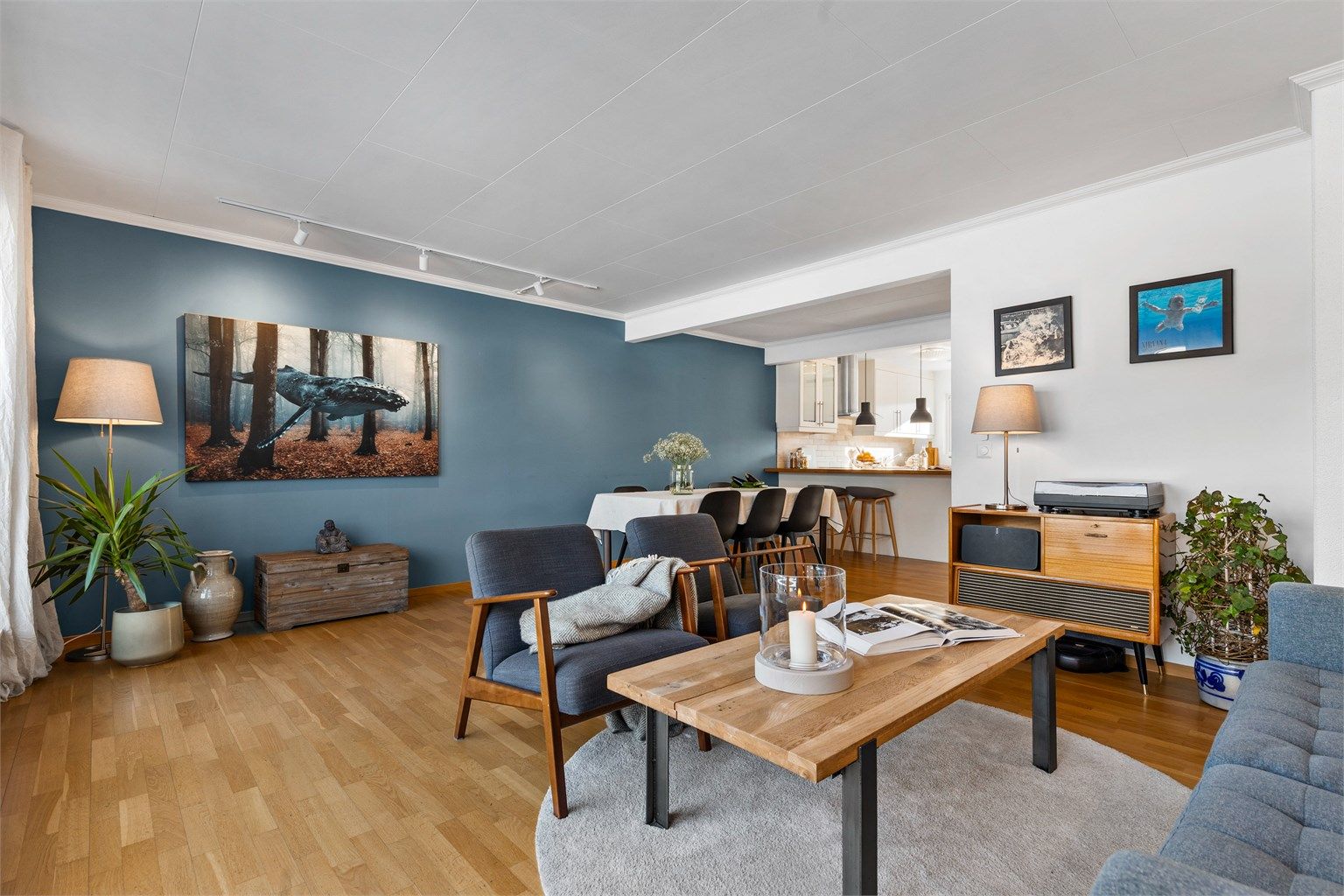 Romslig og lys stue med plass til sittegruppe, TV-område og stort spisebord i spisestuedelen.