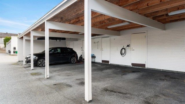Det medfølger parkering i carport, samt en ekstern bod på 5 m².