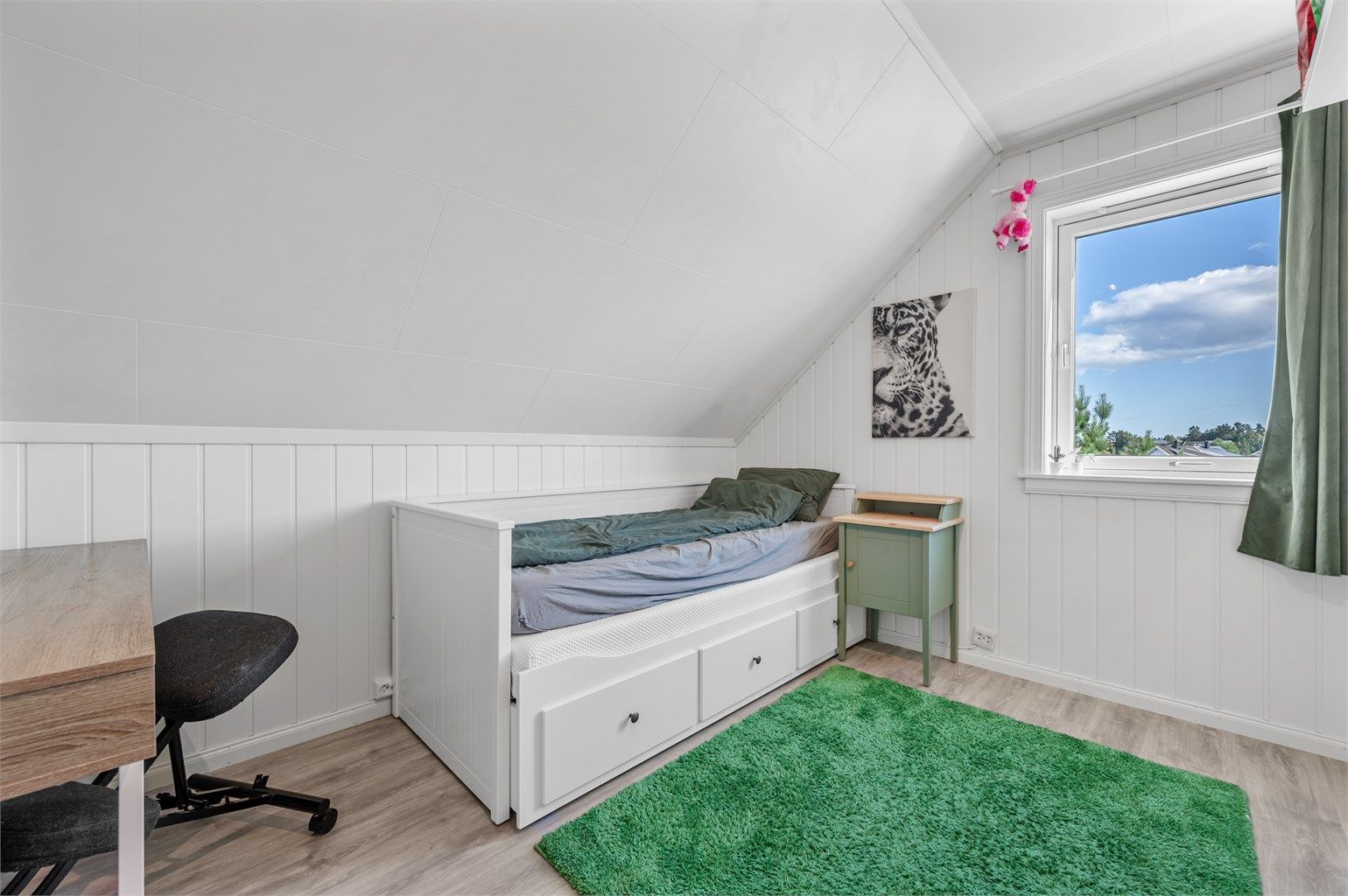 Soverom på loftet med laminatgulv og plass til seng og oppbevaring.