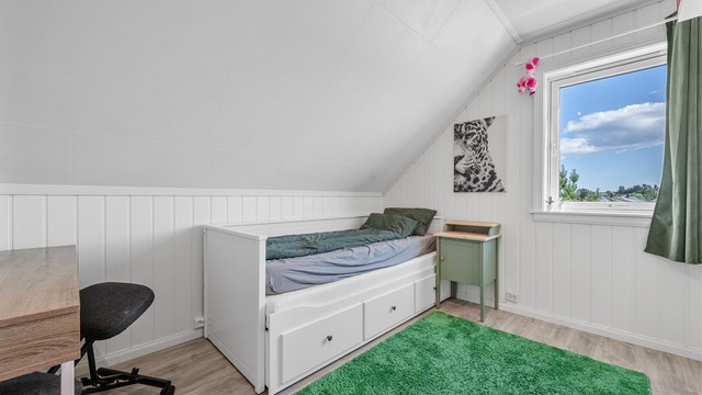 Soverom på loftet med laminatgulv og plass til seng og oppbevaring.