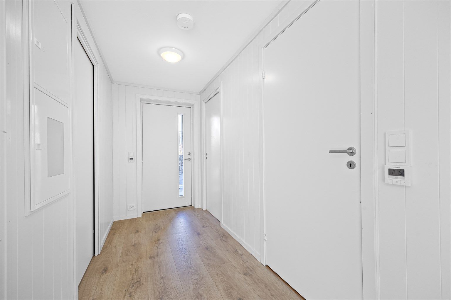 Entré med varme i gulvet og lyse flater.