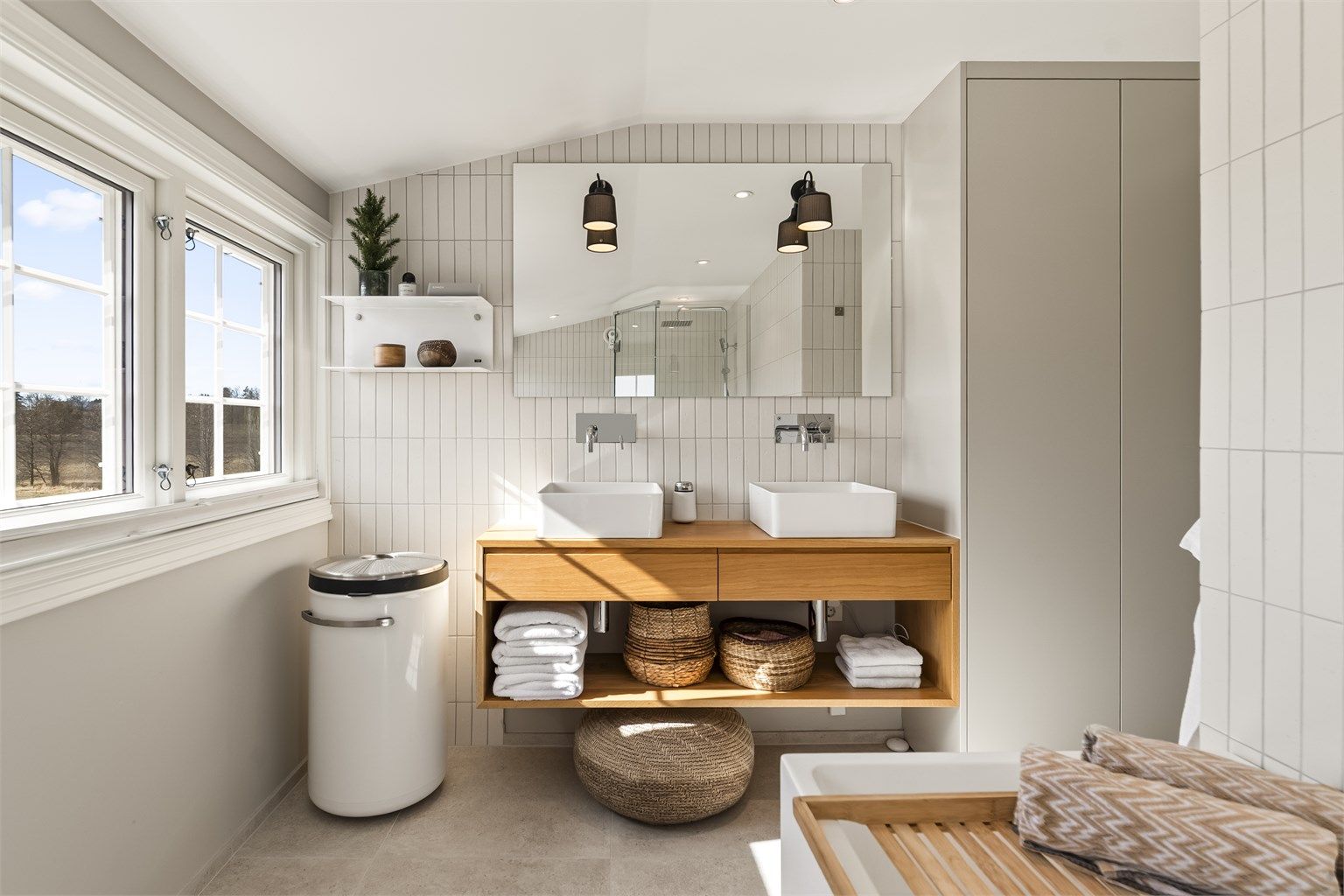 Flislagte overflater og innfelte downlights gir et rent og moderne uttrykk. Vannrør er av typen rør-i-rør.