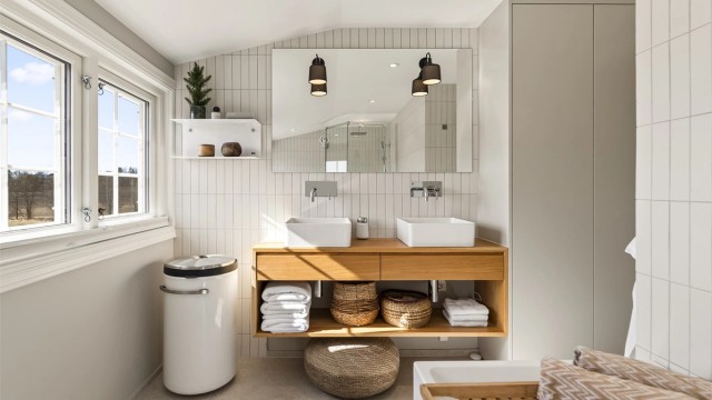 Flislagte overflater og innfelte downlights gir et rent og moderne uttrykk. Vannrør er av typen rør-i-rør.