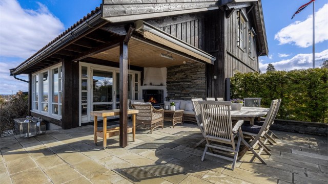 Fra vinterhagen kommer man ut til en flott uteplass med peis.