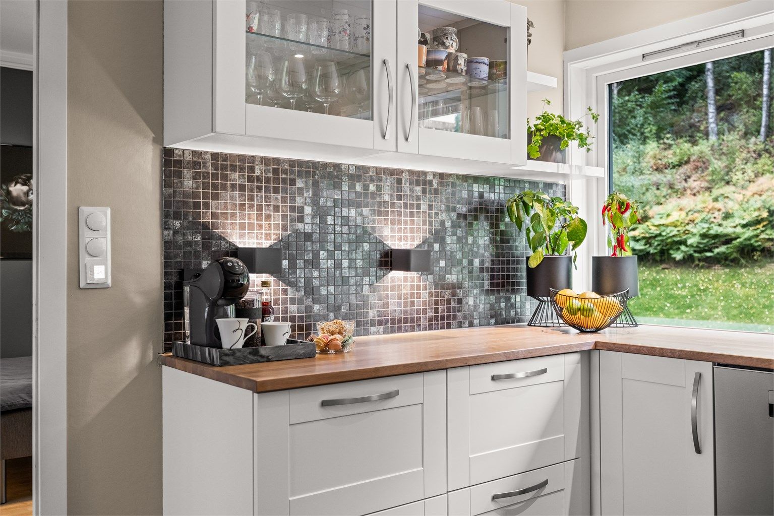 Mosaikkfliser over benken og rikelig med arbeidsflater for matlagingen.