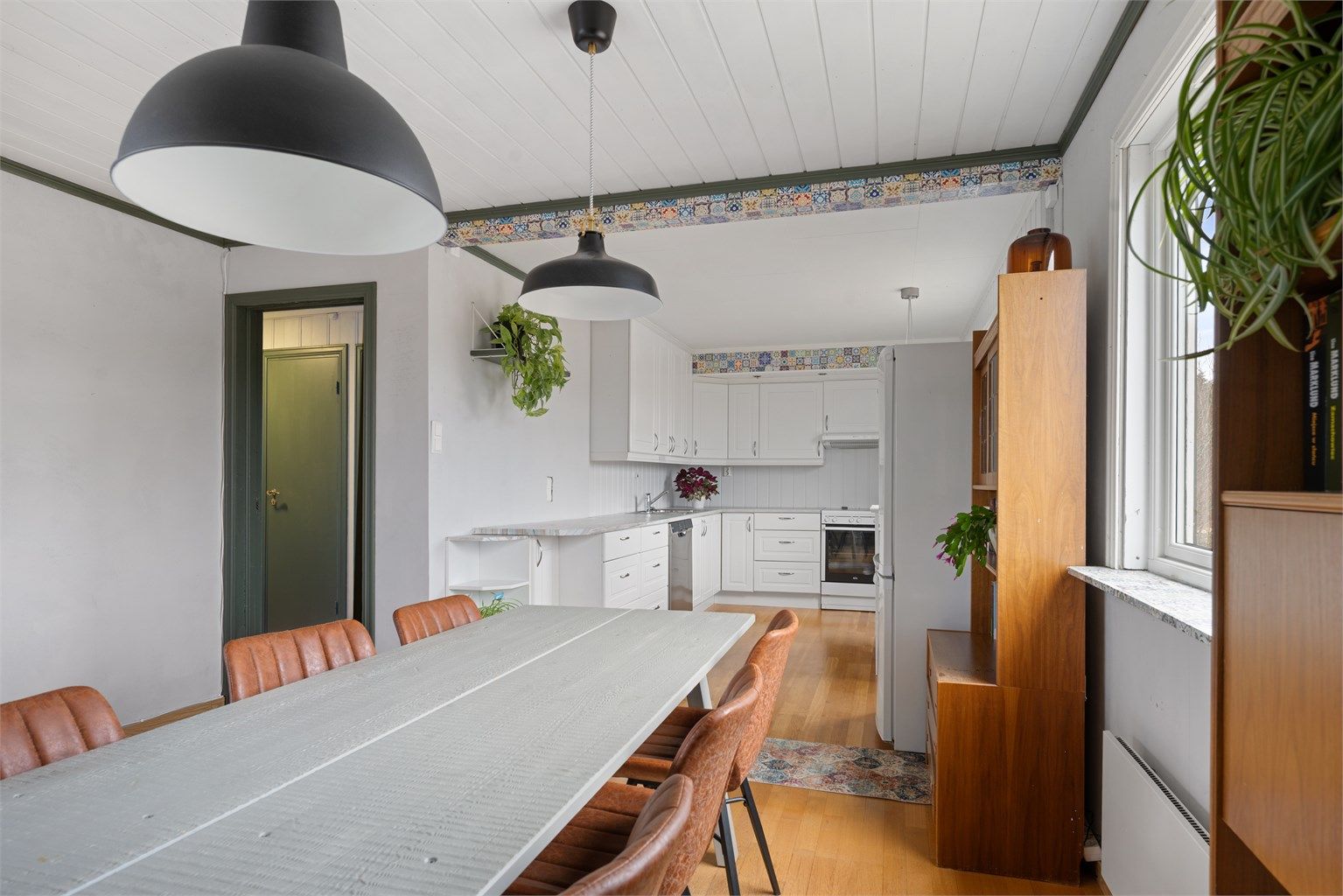 Fra spisestuen ser man rett inn i kjøkkendelen, praktisk for både hverdag og fest.