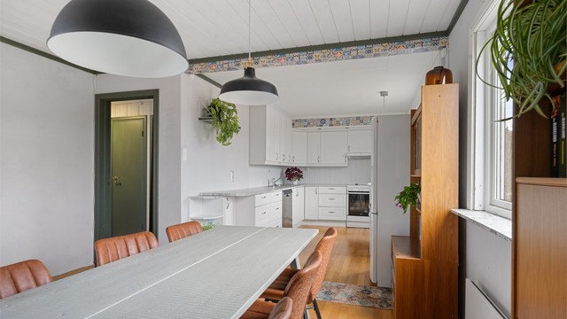 Fra spisestuen ser man rett inn i kjøkkendelen, praktisk for både hverdag og fest.