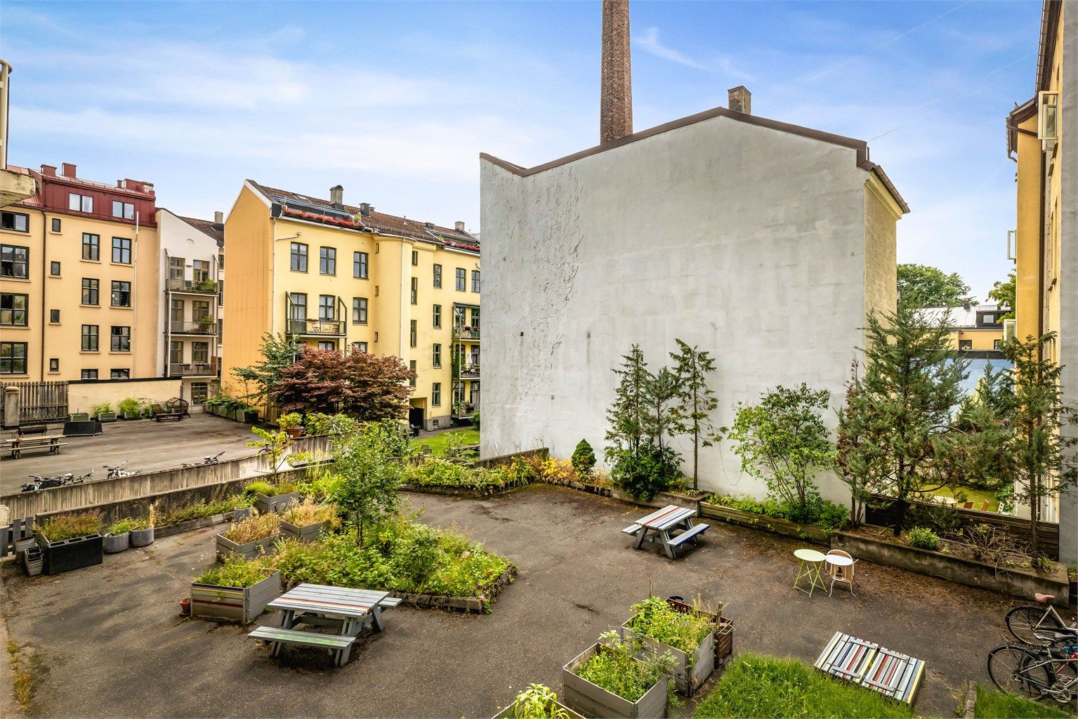 Bakgård til felles bruk for eierne opparbeidet med beplantning og sittegrupper. Det er sykkelparkering. 