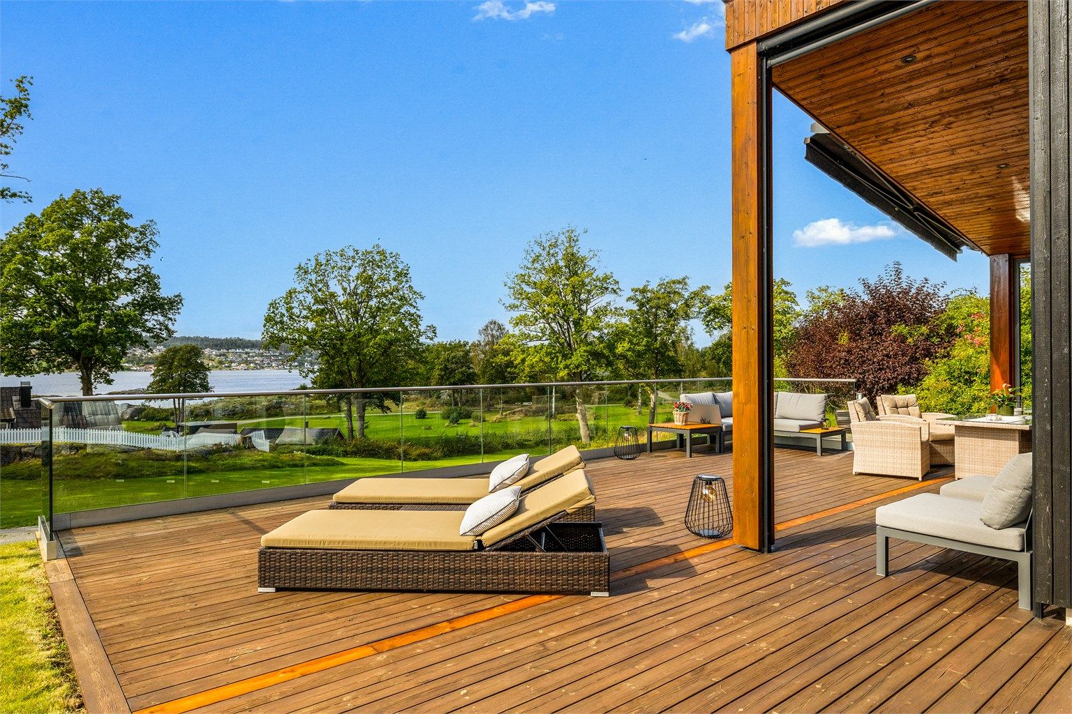 UTEPLASSEN. Utenfor hytta er et en stor terrasse med plass til spisebord, sofagruppe og solstoler. Den store terrassemarkisen er elektrisk og skjermer for sola når man ønsker det.