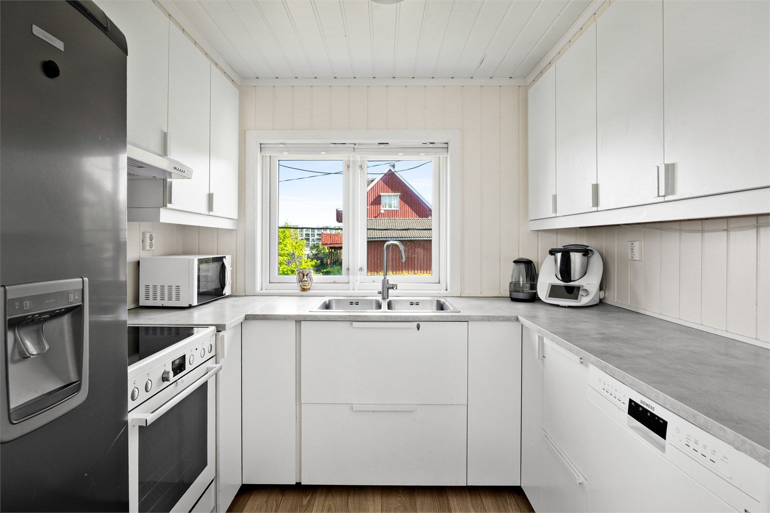 Pen IKEA-kjøkkeninnredning fra 2018. Over- og underskap i hvit samt glatt utførelse.