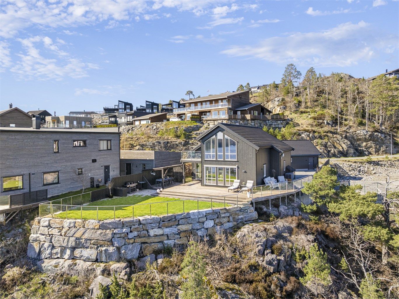 Eiendommen er pent opparbeidet med forstøtningsmurer i naturstein som rammer inn tomten.