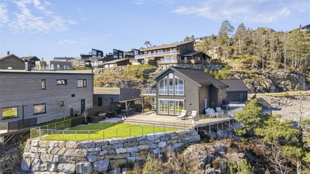 Eiendommen er pent opparbeidet med forstøtningsmurer i naturstein som rammer inn tomten.