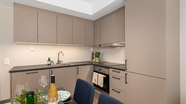 Kjøkkenet er innredet med integrerte hvitevarer og har gode lysforhold over arbeidsflatene.