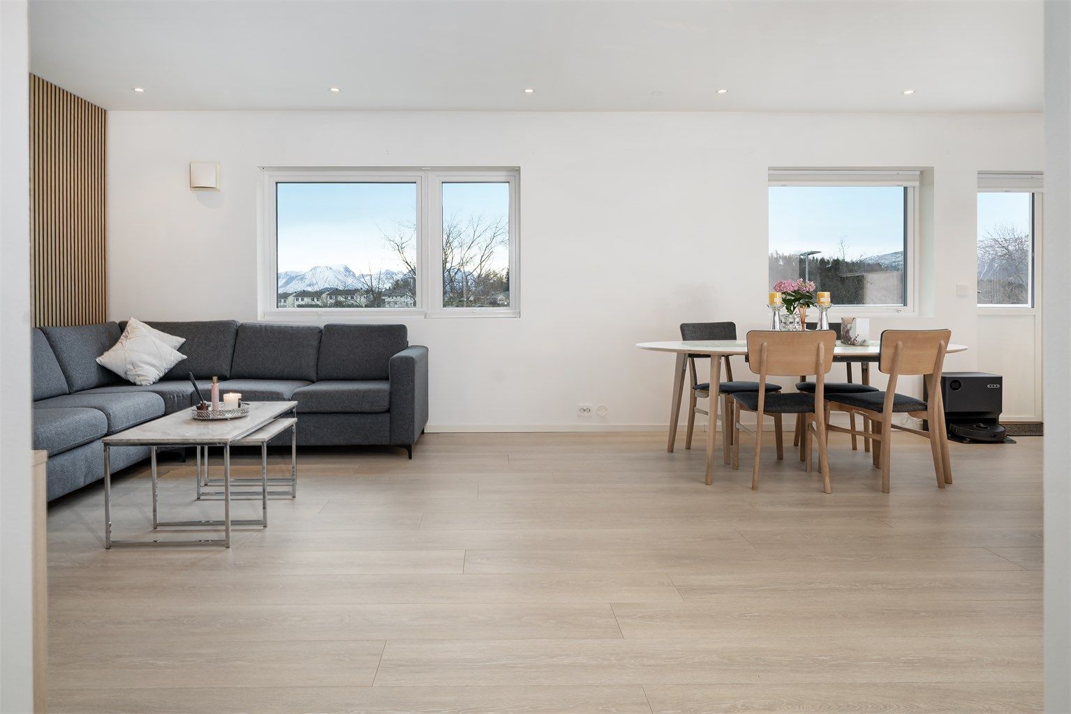 Store vindusflater i stuen slipper inn rikelig med dagslys og skaper en behagelig romfølelse.