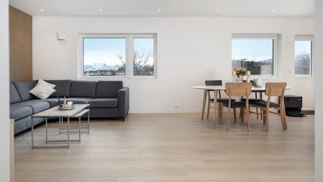 Store vindusflater i stuen slipper inn rikelig med dagslys og skaper en behagelig romfølelse.