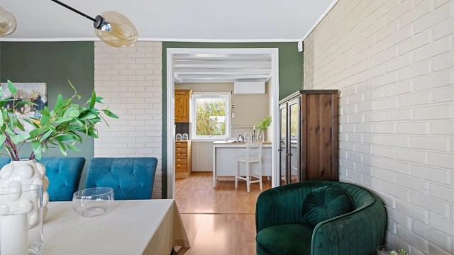 Kjøkken og spisestue i delvis åpen løsning. Vedovn plassert i rommet.