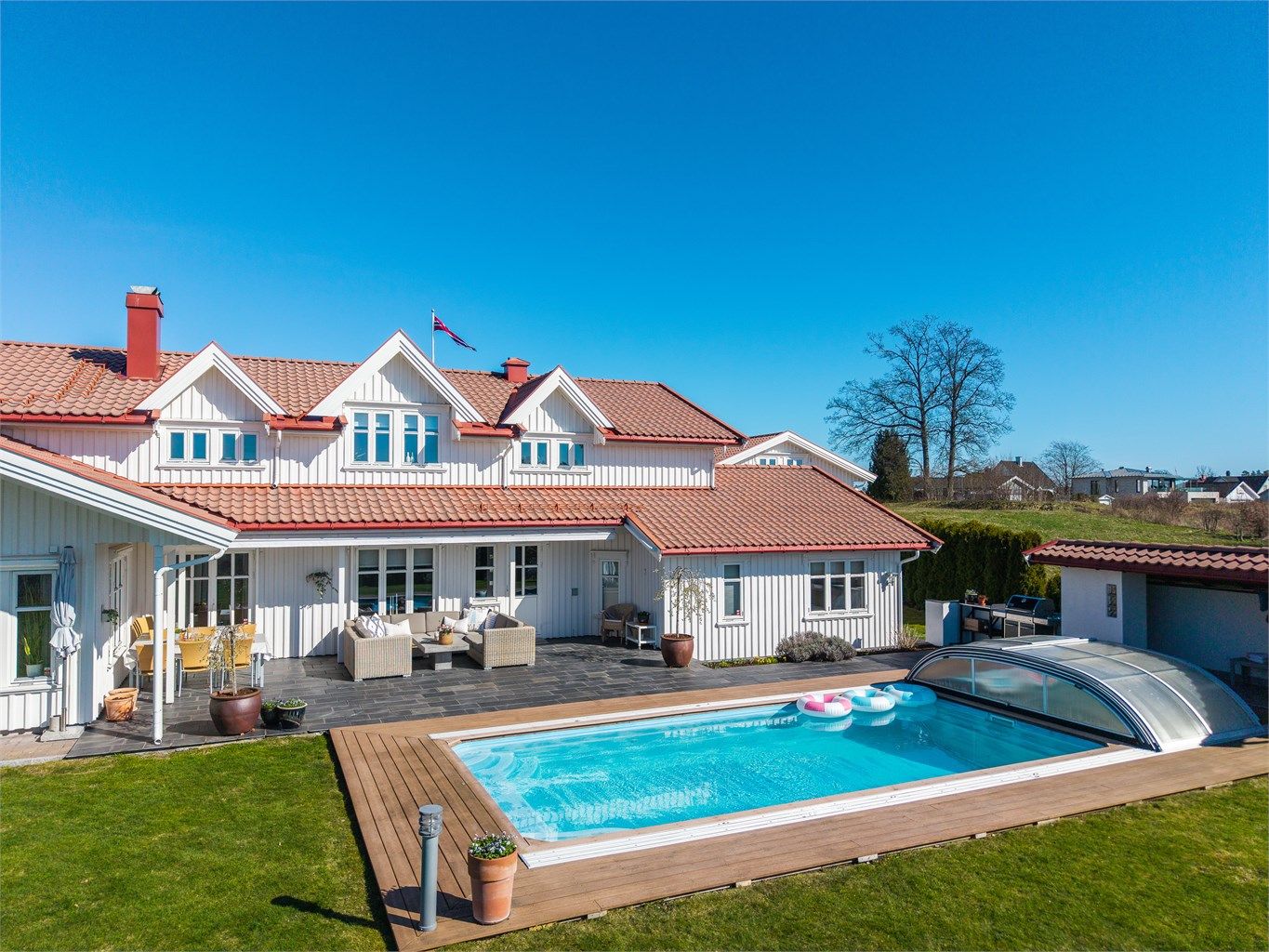 Boligen har en klassisk og tiltalende arkitektur, med stående bordkledning og tak tekket med betongtakstein.