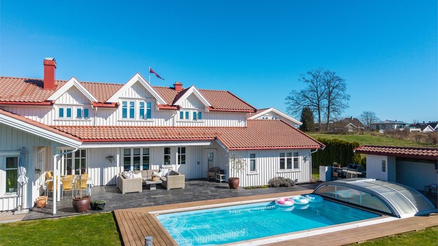 Boligen har en klassisk og tiltalende arkitektur, med stående bordkledning og tak tekket med betongtakstein.