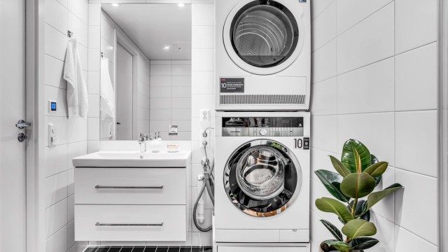 Badet er utstyrt med servantskap med store skuffer og opplegg for vaskemaskin og tørketrommel.